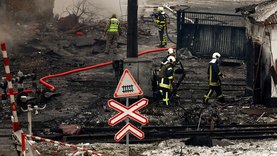 Fire and rescue workers attend to a building hit by a missile in Kyiv.