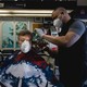 A stylist wearing a protective mask cuts a customer's hair at a barbershop in Atlanta.