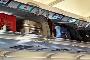 Suitcases packed into an airplane's overhead luggage bins