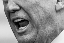 Una foto en blanco y negro de la mitad inferior del rostro de Trump mientras habla.
