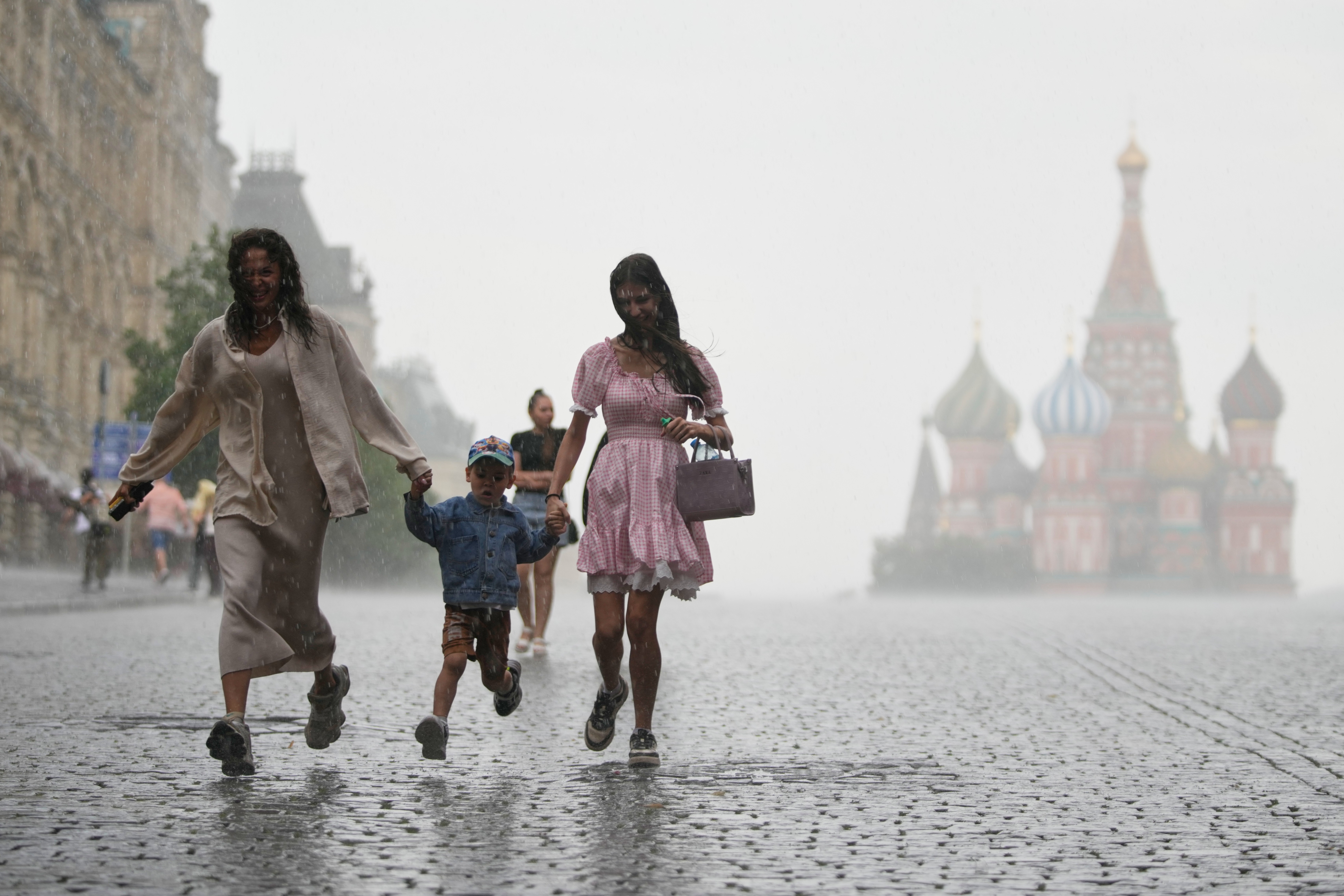 People run through Red Square under pouring rain in Moscow.