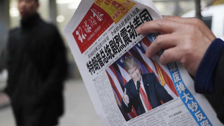 A man reads a newspaper with the headline of "U.S. President-elect Donald Trump delivers a mighty shock to America" at a news stand in Beijing.