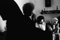 A black-and-white photograph of an interior domestic scene of Sarajevans under siege during war