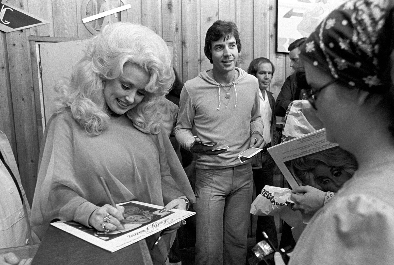 Dolly Parton signs autographs for fans.