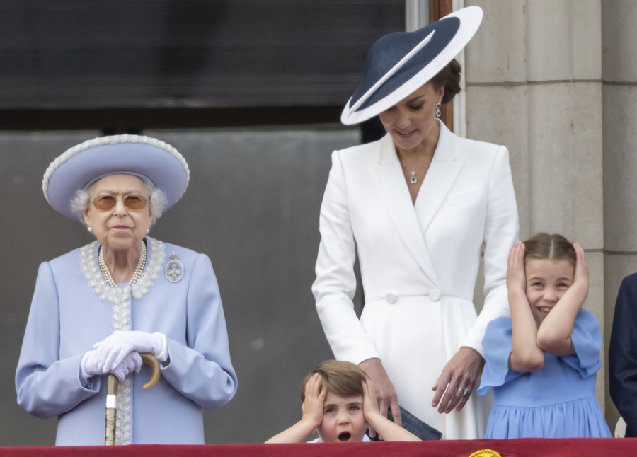 Queen Elizabeth II and three family members react after a flyover.