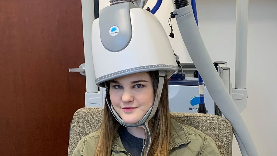 Bre Hushaw wears the BrainsWay "depression helmet" at a clinic in Arizona.