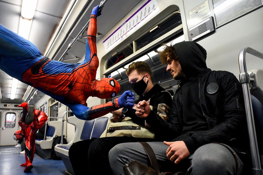 Costumed dancers perform on a subway car.