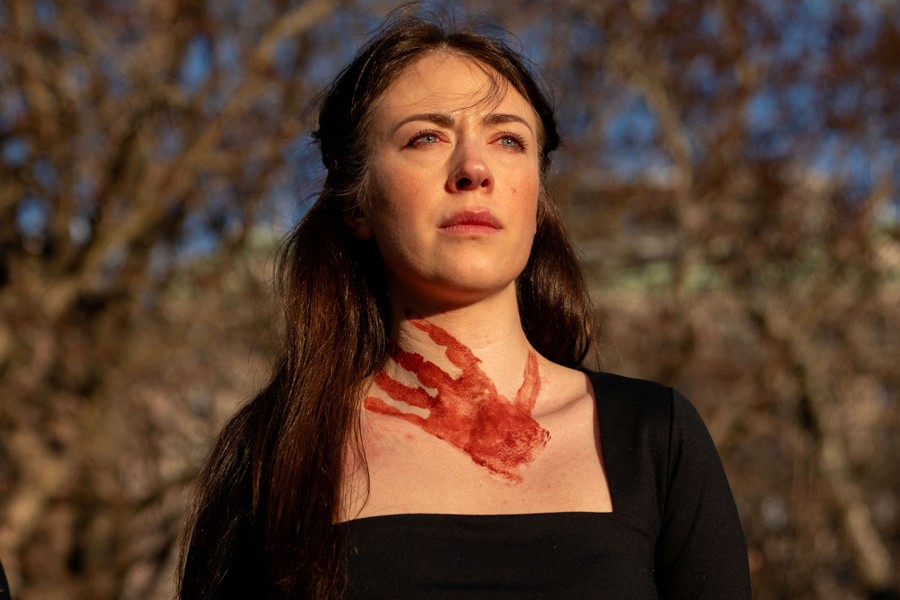 An anti-war protester with what appears to be a bloody handprint on their neck and chest