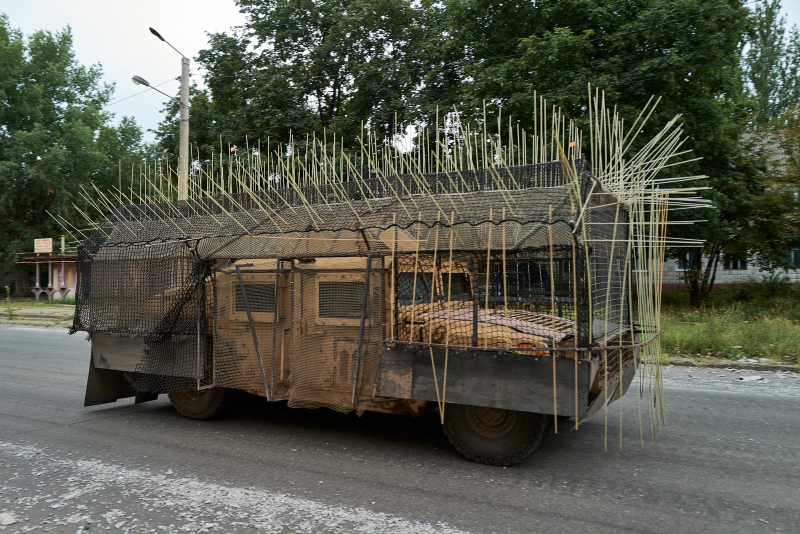 A military vehicle outfitted with an external cage and long spikes
