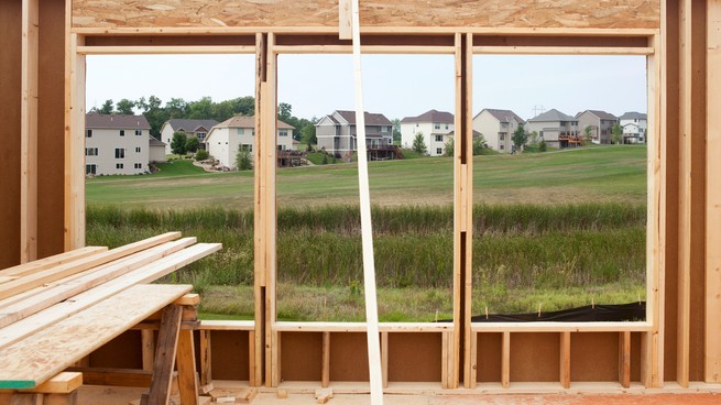 A suburban neighborhood is seen from the windows of a house under construction 
