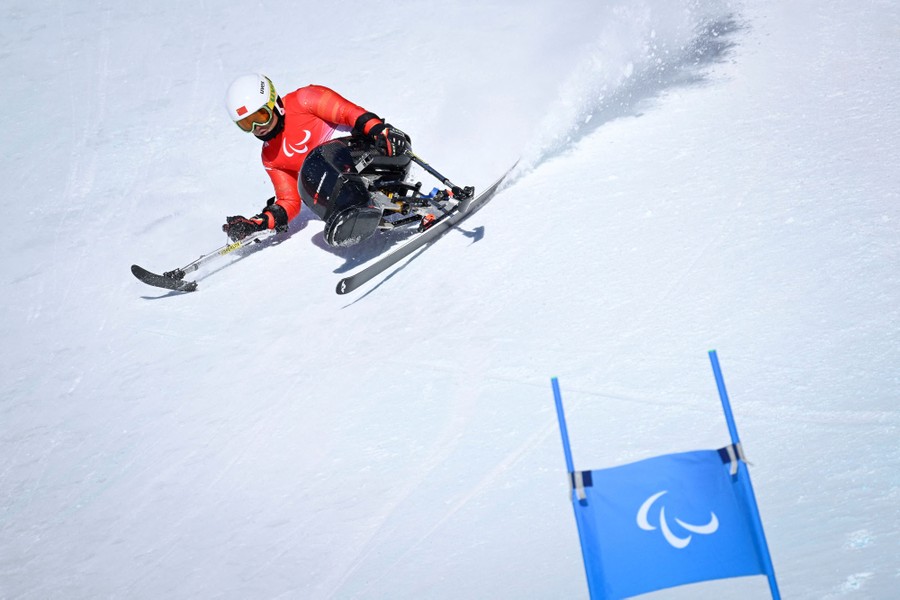 An athlete in the Paralympics runs a training session in the sit-skiing event.
