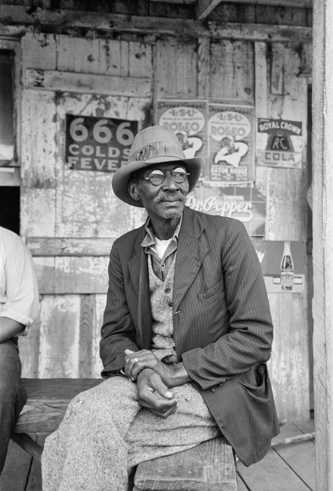 A man on the porch of a general store near Jeanerette, Louisiana, photographed in 1938 by Russell Lee