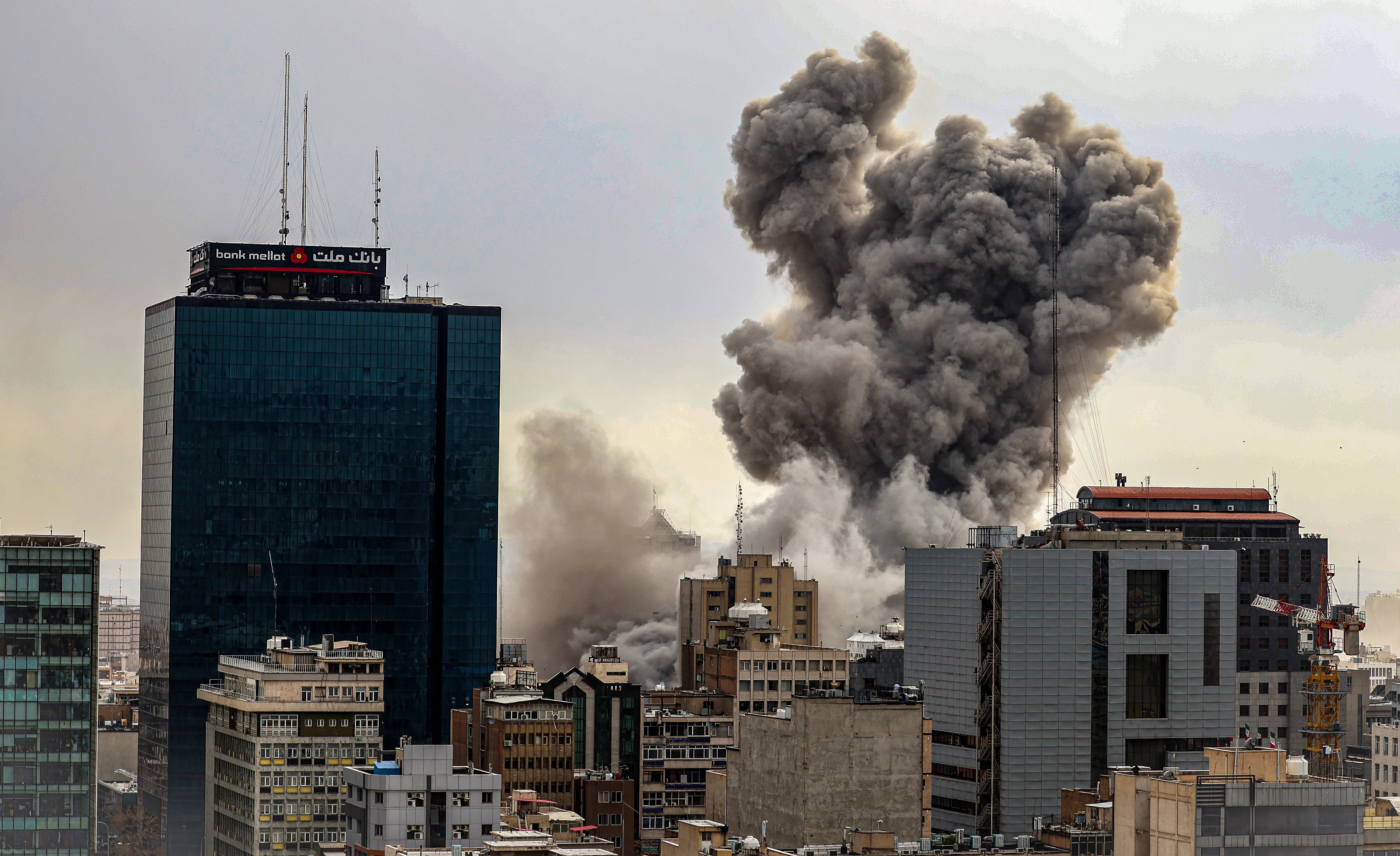 Smoke rises above city buildings after an apparent explosion.