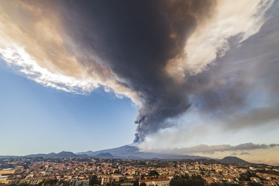 A column of volcanic ash rises from Mount Etna.