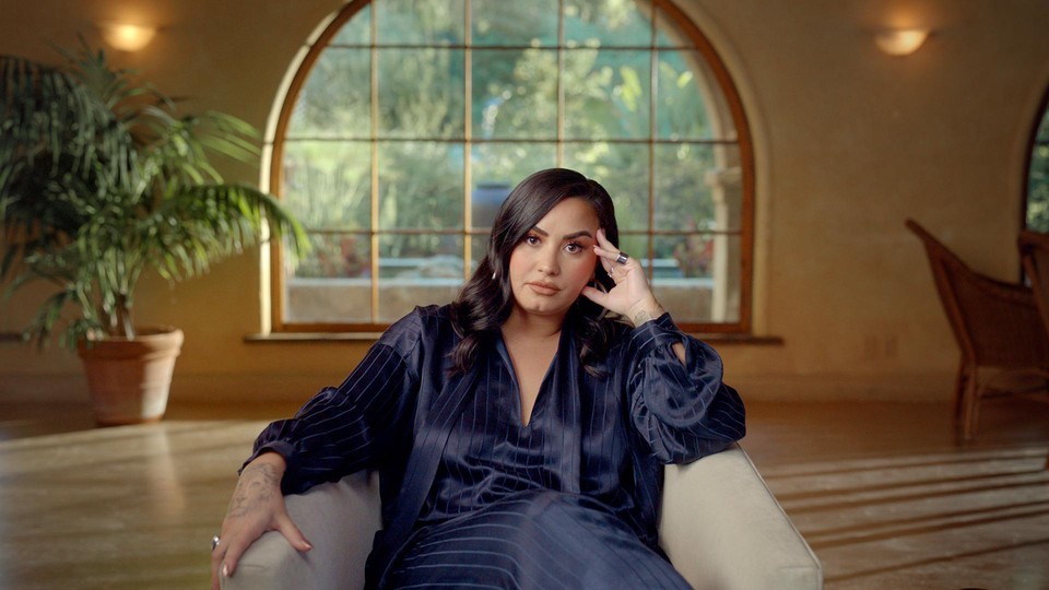 Demi Lovato sitting on a chair in a still from "Dancing with the Devil"