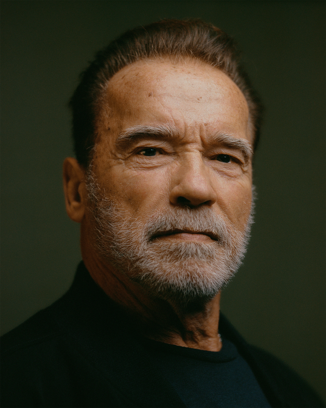Photo of Arnold Schwarzenegger in dark shirt on green background