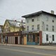Photo of a slightly run-down laundromat on a street with boarded-up building