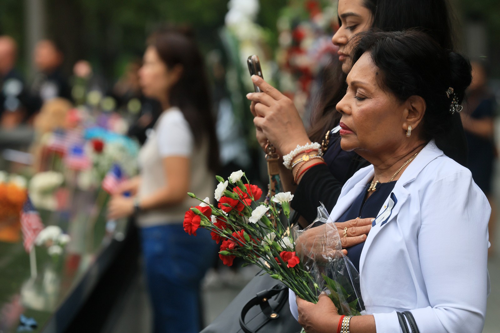 People stand quietly during a memorial ceremony.