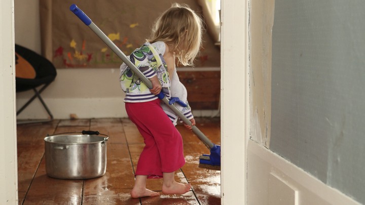 A child mops the floor
