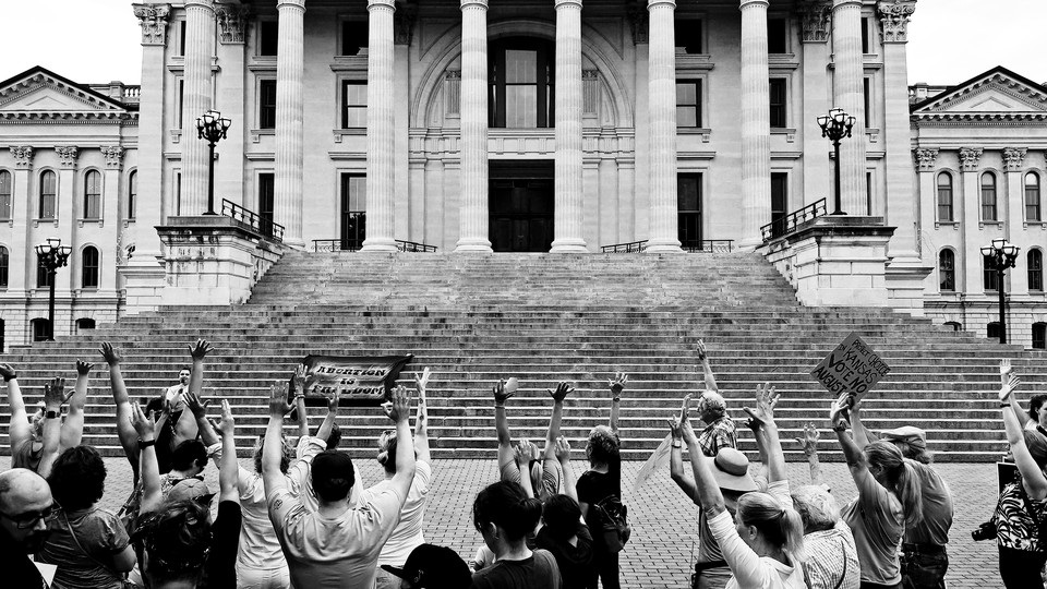 A black-and-white photograph of abortion-rights supporters protesting outside the Kansas statehouse in Topeka