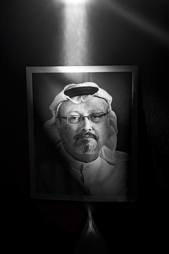 photo of a picture of Khashoggi in black and white with a beam of light shining from above