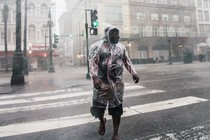 A person crosses a street in New Orleans under heavy rainfall during Hurricane Ida.