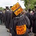 A student at graduation wears a cap that reads "Don't Do Dartmouth." The gown reads "Fight 4 Faculty of Color."