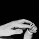 Black-and-white picture showing baby hand gripping tip of index finger of adult hand