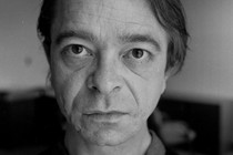 A black-and-white portrait of the writer Gary Indiana, seen head-on from the chest up.