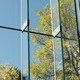 Green trees and a blue sky seen through glass windows