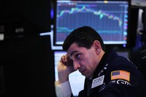 A stock trader looks at a computer screen