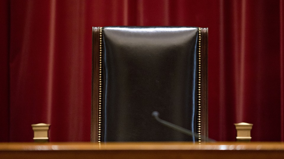 A single black chair in a courtroom