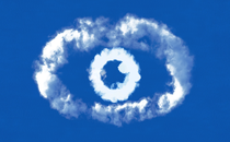 Cloudlike white forms in the shape of an eye against a sky-blue background