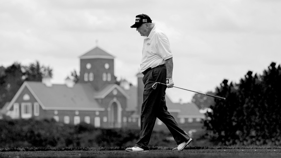 Donald Trump walks holding a golf club at his Bedminster golf club