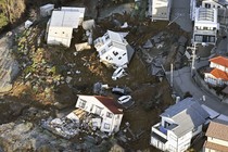 Toppled houses rest in the rubble of a landslide.