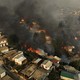 An aerial view of a hillside residential neighborhood with many burning houses
