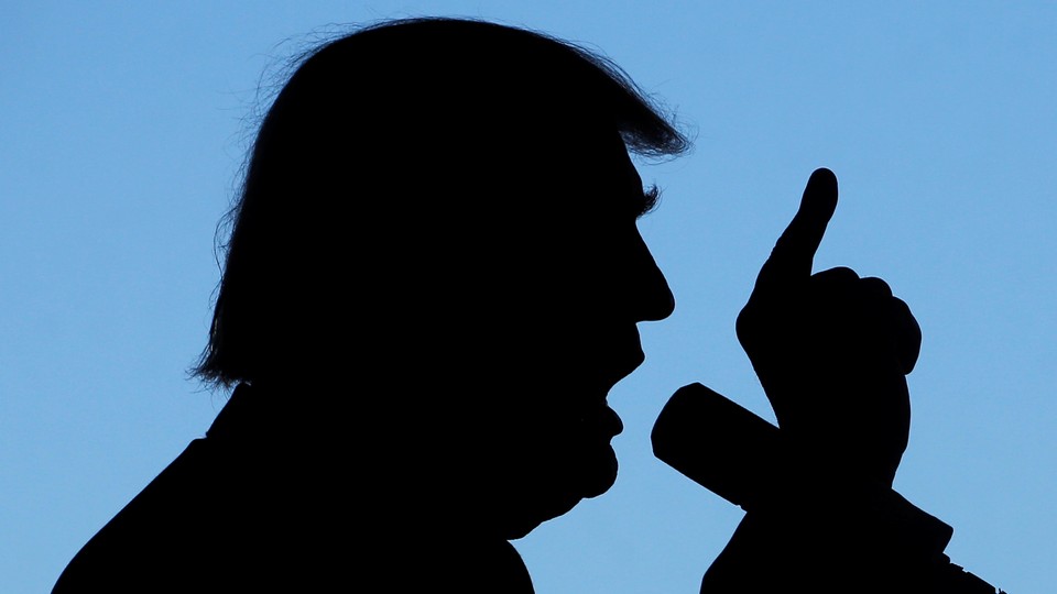 A silhouette of Donald Trump speaking into a microphone