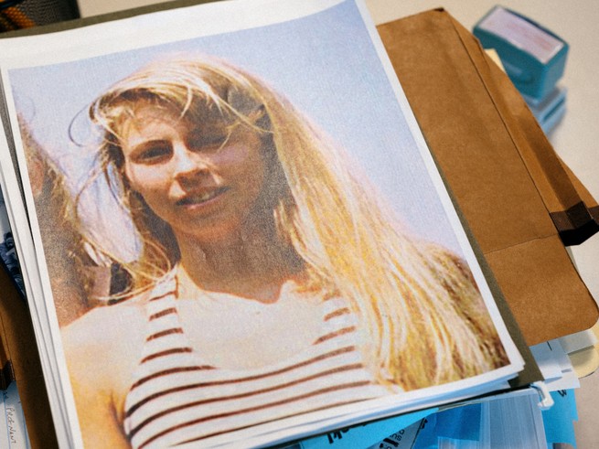 a paper copy of an image of a blonde woman in a striped tank top atop file folders