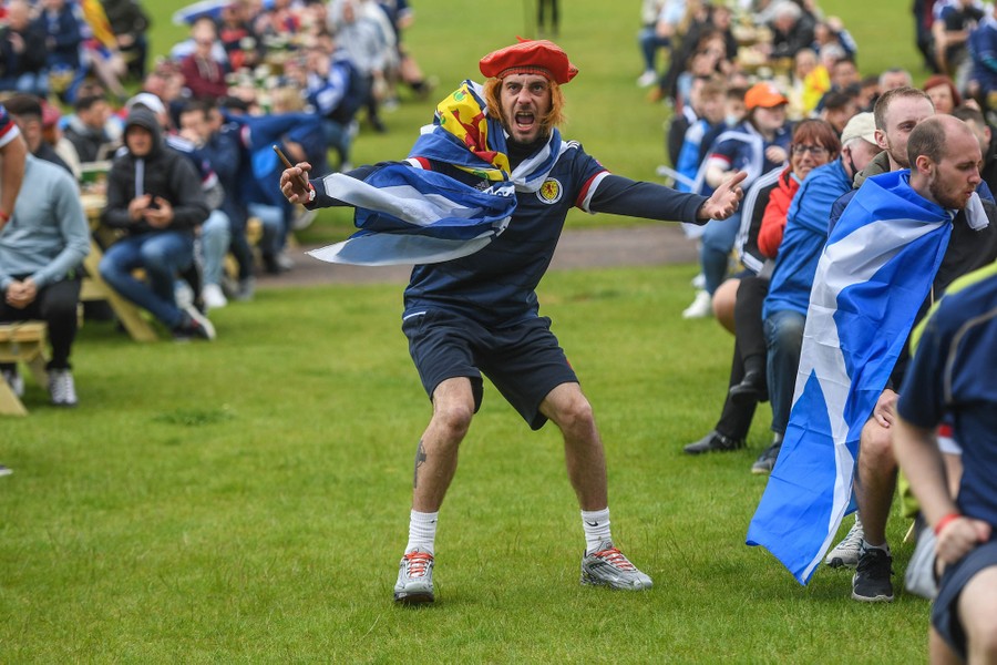 A soccer fan gestures among others watching a match.