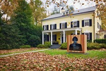 A sculpture of a bust with several image layers stands in front of a campus building at Princeton. 