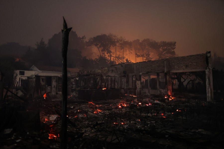A view of a burned-out restaurant, with glowing embers and a smoke-filled sky.