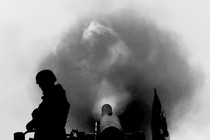 Picture showing the silhouette of a soldier next to a missile and a cloud of smoke