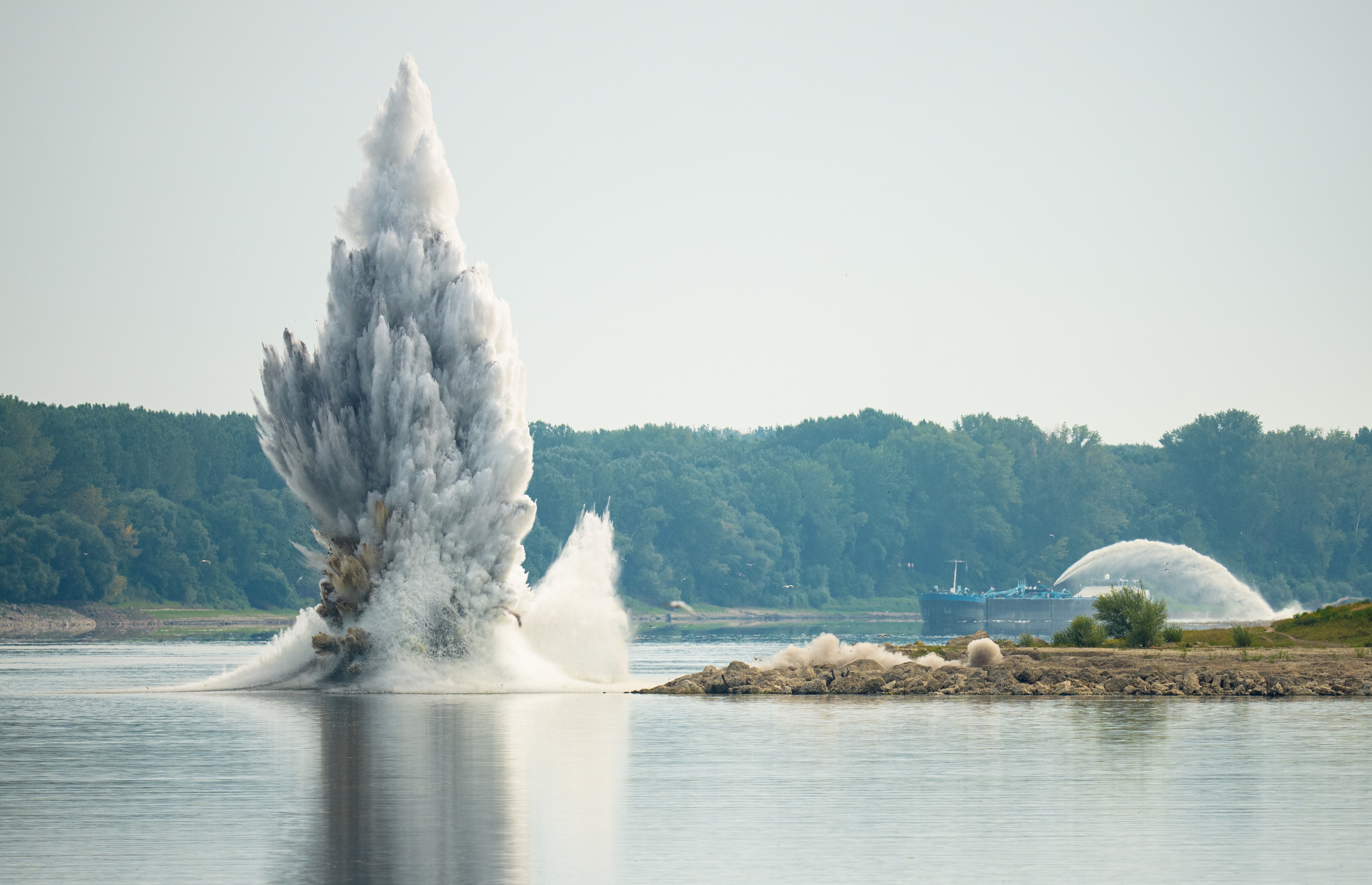 A spray of water rises from a river following an underwater explosion.