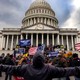 Protesters in front of the U.S. Capitol Building, holding "Trump 2020" signs and American flags
