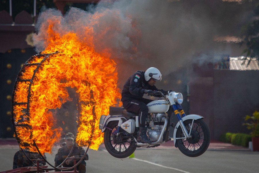 A person jumps a motorcycle through a hoop of fire.