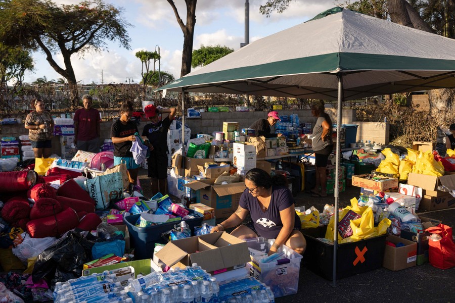 Volunteers sort out donations in a parking lot.