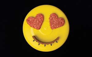 photo of yellow frisbee with 2 heart-shaped ground-beef patties as eyes and arc of dog collar as smile