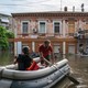 Rescue workers paddle a boat through flooded streets in Kherson.