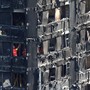 Members of the emergency services work inside burnt out remains of the Grenfell apartment tower on June 18, 2017.