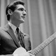 A black and white photo of a young Steve Cropper, in profile, holding his guitar